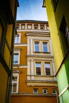 Unique architectural view between colorful buildings in a quiet urban alley Stock Photos