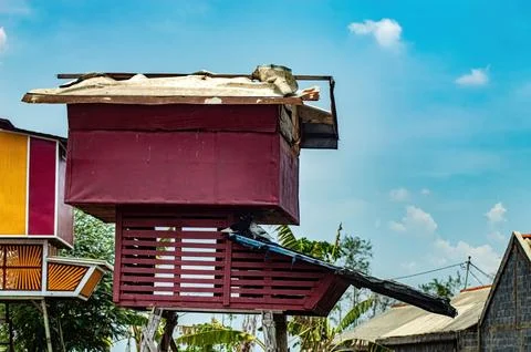 A unique birdhouse with a rustic design, elevated on stilts, featuring a re.. Stock Photos