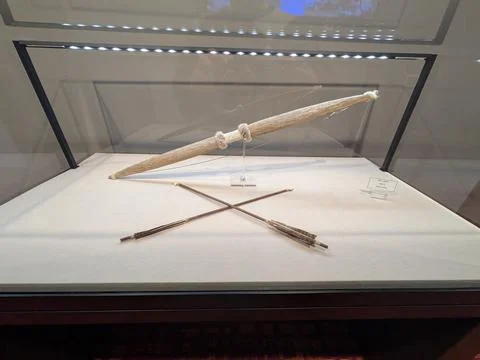 Unique bow and arrow set with feathered details displayed in glass Foto stock