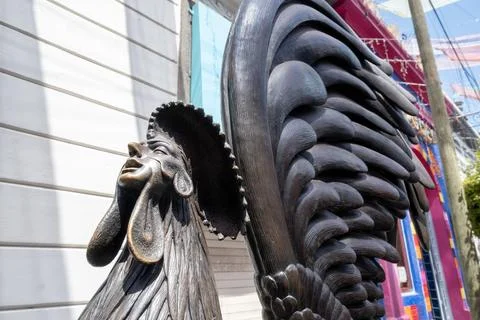 Unique bronze rooster man statue by a colorful building in Tlaquepaque, Jalisco, Stock Photos