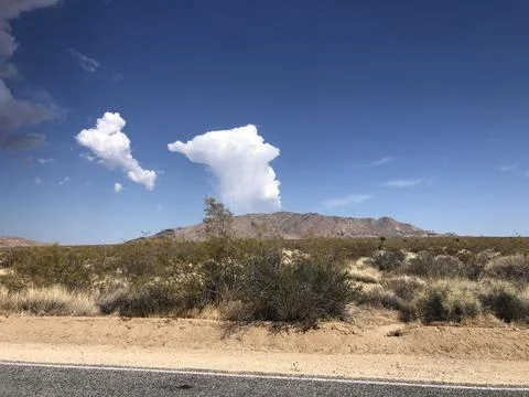 Unique Cloud Formation Over Desert Landscape in Bright Daylight Sun Stock Photos