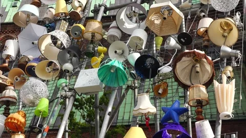 Unique collection of lamps displayed on a wall in an urban area Video stock 345055984