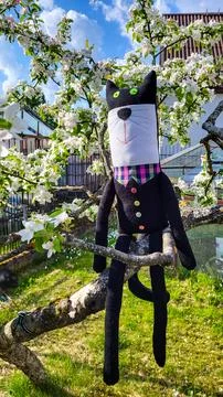 Unique Decorative handmade stuffed cat in vest resting among blossom branches 스톡 사진