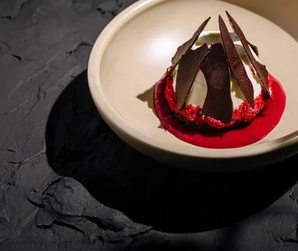 Unique dessert presentation featuring layers of red and chocolate elements Stock Photos