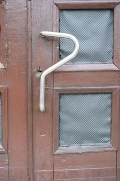 Unique door handle design on rustic wooden entrance Photos