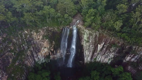 Unique drone view through suspended mist revealing a majestic waterfall spilling Stock Footage 294635803