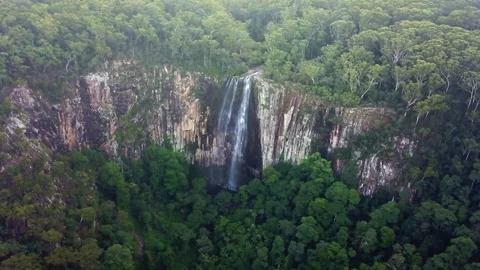 Unique drone view through suspended mist revealing a majestic waterfall spilling Stock Footage 294636048