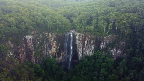 Unique drone view through suspended mist revealing a majestic waterfall spilling Video stock 294636085