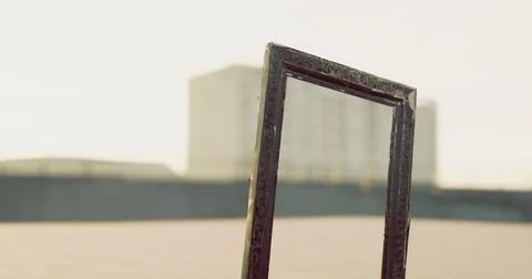 Unique empty frame standing in a vast outdoor space under clear sky Stock Illustration