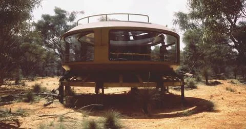 Unique futuristic structure in arid landscape surrounded by trees Ilustración de archivo