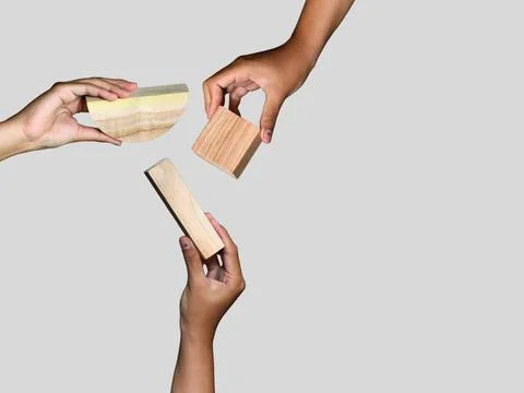 Unique hands holding a different piece of the wooden puzzle, teamwork Stock Photos