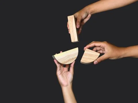 Unique hands holding a different piece of the wooden puzzle, teamwork Stock Photos
