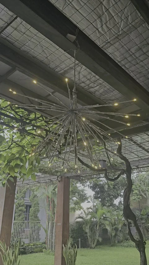 Unique Hanging Light Fixture Amidst a Verdant Outdoor Setting Stock Footage 296720019