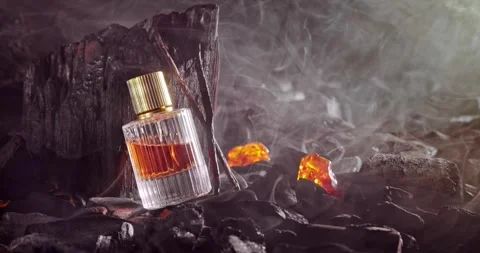 Unique incense perfume in translucent glass bottle on coal. 库存影片 332252174