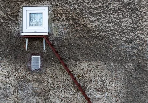 Unique ladder For a Pet leading to small window on textured wall in urban Stock Photos