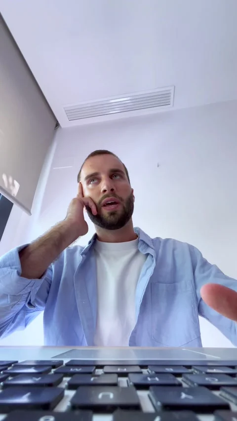 Unique low-angle perspective of a young caucasian man concentrating and typing Stock Footage 346600608