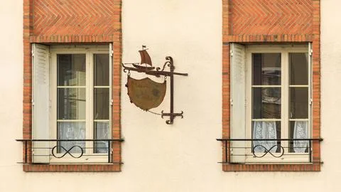 Unique old windows surrounded by bricks with shutters Stock Photos
