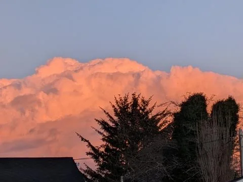Unique orange and white cloud formation above greenery Stock Photos