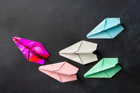A unique paper plane with some regular ones, leadership concept on the tables Stock Photos