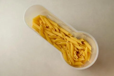 Unique pasta display in a clear container creates an artistic kitchen moment Stock Photos