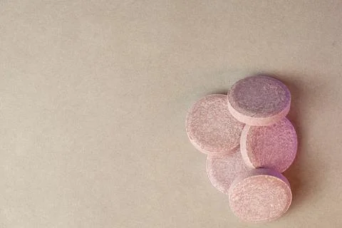 Unique pastel tablets arranged elegantly on a soft surface for wellness Stock Photos