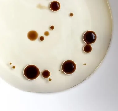 Unique pattern of soy sauce droplets on a white plate creates an artistic c.. Stock Photos