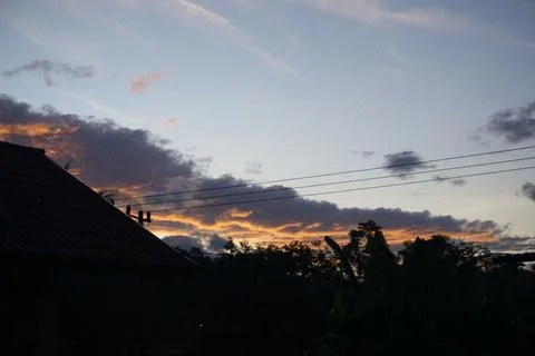 Unique photo of clouds at dusk, clouds behind houses and electricity cables Stock Photos