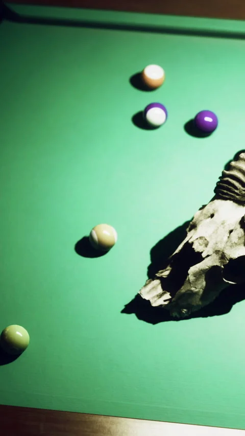 Unique pool table setup featuring a ram skull surrounded by billiard balls Stock Footage 329753559