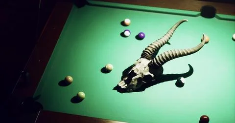 Unique pool table setup featuring a ram skull surrounded by billiard balls Stock Illustration