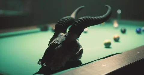 Unique pool table setup with ram skull and colorful balls in dim light Stock Illustration