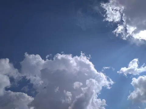 A unique rare view of sun rays filtering through the white clouds Stock Photos