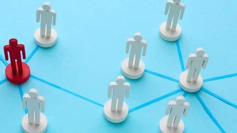 Unique red figure connects to network of white figures Stock Photos