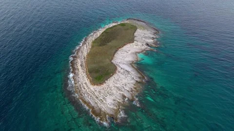 Unique remote Kidney shaped Island surrounded by beautiful sea Stock Footage 287548004