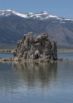 Unique rock formation rises from tranquil waters under clear blue skies nea.. Stock Photos