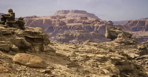 Unique rock formations against a dramatic desert landscape under clear skies Illustrazione stock