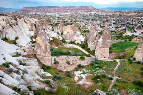 Unique rock formations tower majestically over the verdant valleys of Cappado 스톡 사진
