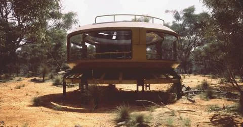 Unique round house amidst sparse vegetation in arid landscape Ilustración de archivo