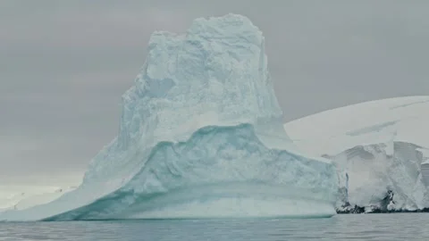Unique Sculpted Antarctic Iceberg Tower Rising From Wave-Eroded Base in Calm 스톡 동영상 334079231