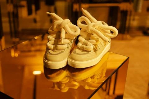 Unique sneaker design displayed elegantly in a boutique setting with warm l.. Stock Photos