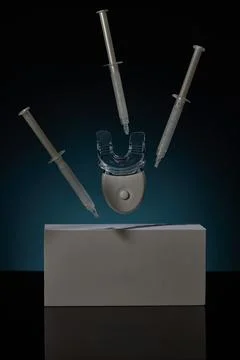 Unique teeth whitener kit displayed against a dark background with syringes and Stock Photos