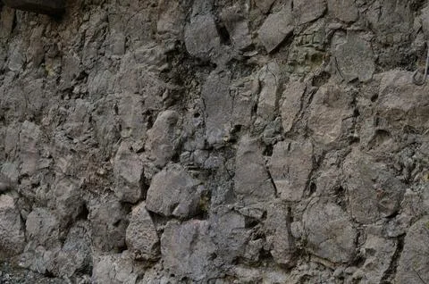 Unique texture of an ancient stone wall illuminated by soft natural light i.. Stock Photos