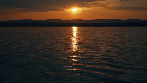 A unique time lapse with a view of the lake and mountains at sunset. Stock Footage 342639342