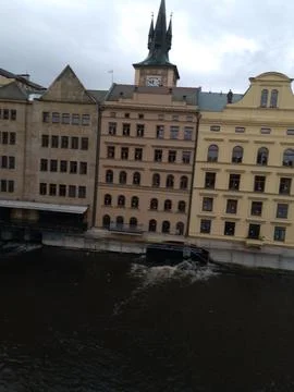 A unique tower with a clock rises above historic buildings Stock Photos