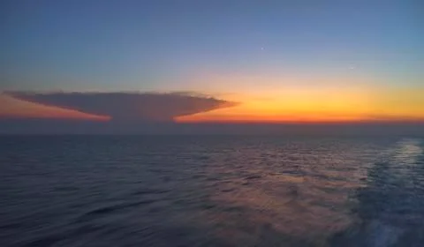 Unique unknown cloud object on vivid sunset seen from ferry boat travel trip Foto stock