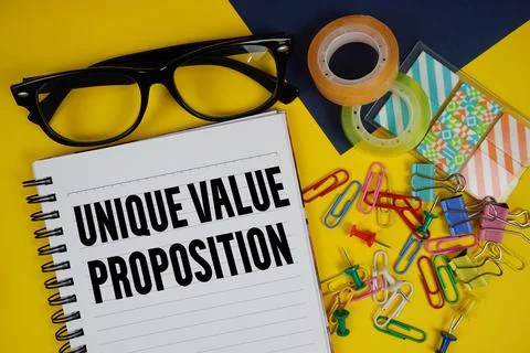 Unique Value Proposition text with eyeglasses and stationery on yellow back.. Stock Photos