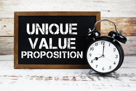 Unique Value Proposition text message and alarm clock on wooden background Stock Photos
