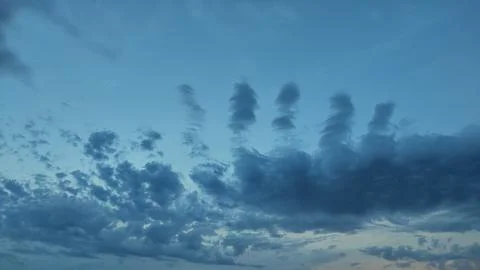 Unique vertical cloud formations rising in blue sky 스톡 사진