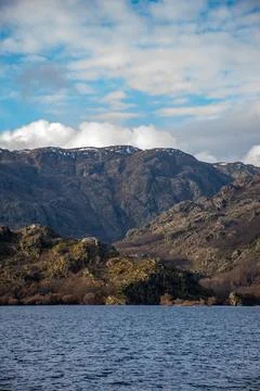 Unique vertical view from a boat in the middle of a lake with calm water and  Stock Photos
