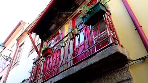 Unique view of a tiny street of Porto with vibrant red doors on a balcony, Stock Footage 248195851