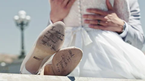 Unique wedding shoes signed by bride and groom displayed outdoors Stock Footage 310152297